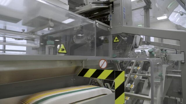 Pharmaceutics. Pharmaceutical worker operates blister packaging machine. Medical products manufacturing in a modern factory - operator at modern industrial plant