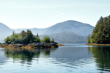 Fototapeta premium An Alaskan landscape with mountains water trees and mist.