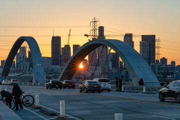 Fototapeta na wymiar Lens flare at sunset on the 6th street bridge in Los Angeles with the skyline in the distance