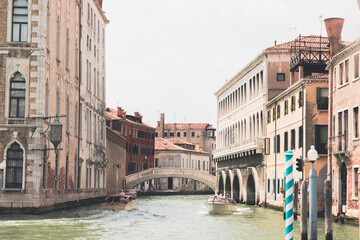 Boats and gondolas passing near Rialto Bridge in Venice