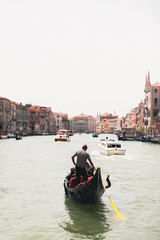 Fototapeta na wymiar Boats and gondolas passing near Rialto Bridge in Venice