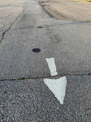 White Arrow on Asphalt Road Pointing Down