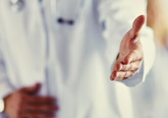 friendly male doctor with open hand ready for handshake