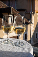 Tasting of white grand cru classe chablis wine with old French houses on background, Burgundy, France