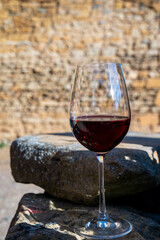 Tasting of red wine by old wine maker in Pierres Dorées region with yellow stone houses on south of Beaujolais region, France