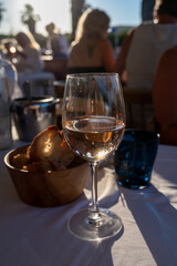 Dinner at sunset in French restaurant with cold dry rose wine in Port Grimaud, summer vacation on French Riviera, France