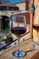 Tasting of red wine by old wine maker in Pierres Dorées region with yellow stone houses on south of Beaujolais region, France