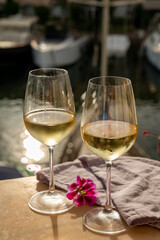 Drinking of cold white wine  with view on yacht harbour of Port Grimaud, summer vacation on French Riviera, France