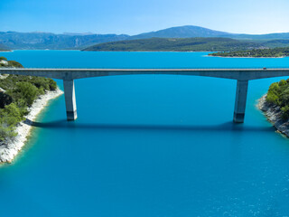 Fototapeta na wymiar Aerial view on blue lake Sainte-Croix-du-Verdon, road bridge and cliffs, tourists destination in France