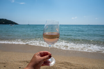 Cold rose wine from Provence served outdoor on white sandy beach Plage de Pampelonne near Saint-Tropez, France