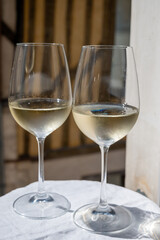 Tasting of white grand cru classe chablis wine with old French houses on background, Burgundy, France