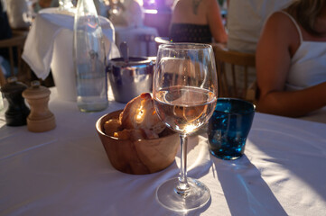Dinner at sunset in French restaurant with cold dry rose wine in Port Grimaud, summer vacation on French Riviera, France