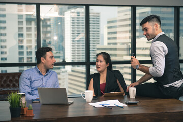 businessman and woman discussing about a meeting at office space. Three business people use computer laptop and talking together at office indoor.