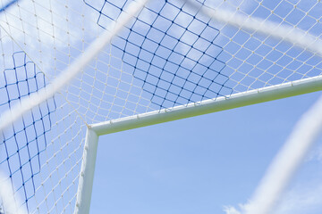 Behind the ropes of the outdoor soccer field goal net, the football goal background