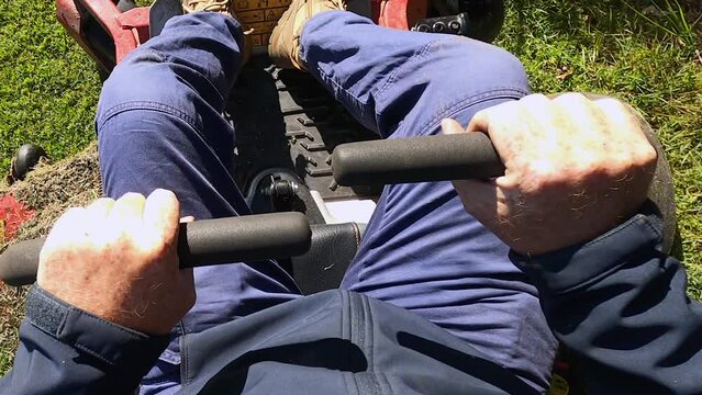 Slow motion point of view of a man turning and reversing a tractor mower. POV.