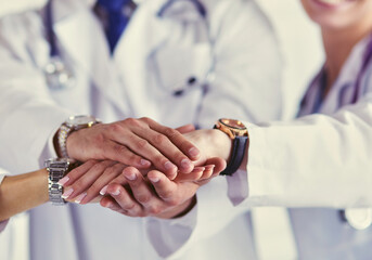 Doctors and nurses in a medical team stacking hands