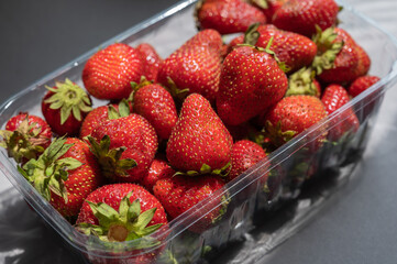 Ripe strawberries close-up. A new crop of sweet berries in a transparent tray. Healthy Food. Selective focus.