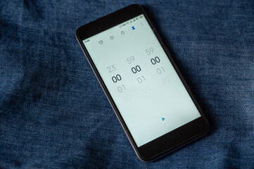 Black smartphone with the Time Countdown App open. Zeros on the screen of the device. The starting...