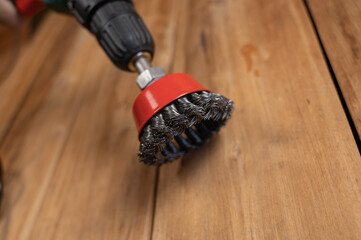 Knot cup wire brush installed in the cam of the power drill chuck. Tool for woodworking, sanding,...