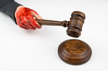 Female judge with bloody hands beats the gavel on a white background.