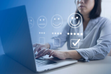 Satisfaction and customer service survey concept, business people using  laptop. to answer the questionnaire And the satisfaction rating, the satisfaction rating with the smiley face icon 5 stars.