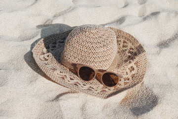 Straw hat and sunglasses on the beach white sand