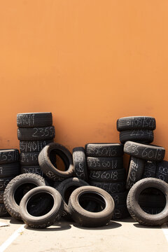 Stacked tires await disposal outside of a tire repair shop.