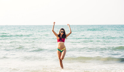 Portrait of smiling fashion woman relaxation on the tropical beach.Happy young beautiful girl enjoying and having fun on the tropical island.Summer vacation and travel