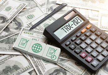 Tax. The word tax is on calculators and paper dollars.  Business and tax ideas. Taxation. New year tax ideas.