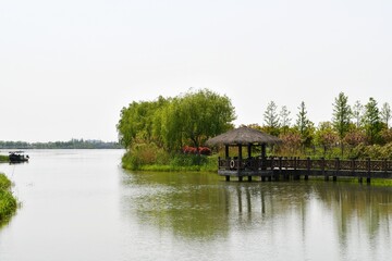 a traditional Chinese wooden pavilion on the water