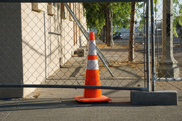 Traffic cone behind fence at construction site