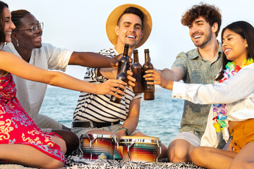 Cheers. Smiling friends enjoy some cold beer at the beach. Diverse happy young people toasting with beer outdoors.