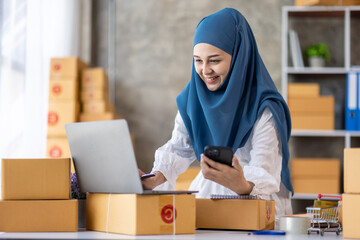 Muslim young Asian woman working at home doing sme ecommerce online small business entrepreneur...