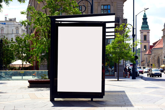 image composite of bus shelter at bus stop. blank lightbox and glass structure. city street setting with traffic. urban background. blank white glass poster ad. commercial poster space. mockup base.