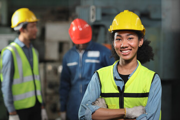 Confident technician engineer woman in protective suit standing and arms cross while looking camera and maintenance operation work lathe metal machine at heavy industry manufacturing factory