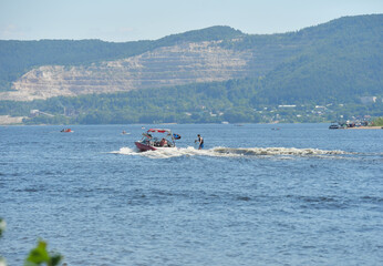Obraz premium Water skiing behind a boat on the Volga River on a summer day .