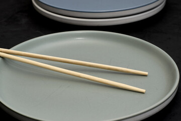 two plates and chopsticks on a black background