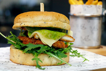 crumb fried chicken burger with focaccia bun, rucola leaves, pesto sauce and fontal cheese