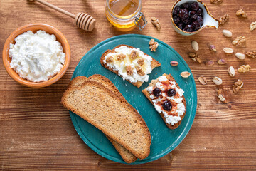 prima colazione ricotta su fette di pane con miele e  amarene e noci 