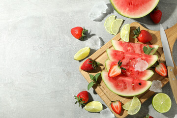 Fresh and juicy fruits with ice on gray textured background