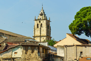 Tower of the Gothic church of Torrelaguna on the roofs of old houses in ruins, Madrid.