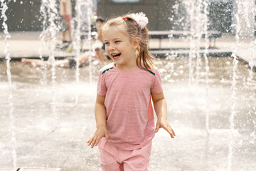 Girl in a spray of water in a fountain