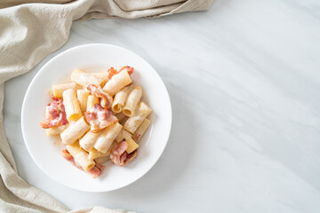 spaghetti rigatoni pasta with white sauce and bacon