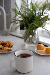 Fototapeta na wymiar christmas holidays food - tea cup, tangerine and poppy seed buns