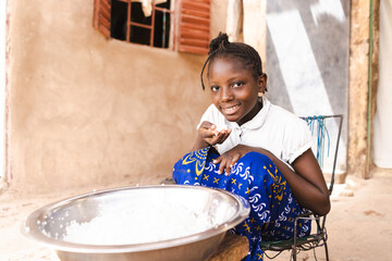 Poor African girl eating white rice without dressing, vegetables or meat; importance of staple food...