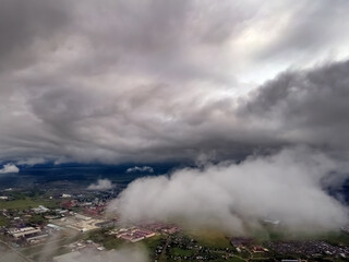 Flying through thick clouds. Rain clouds in the sky. Cumulus clouds, meteorology and climate studies.Photo of the city from the height of clouds, aerial photography.Quadcopter,drone