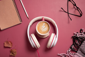 Fototapeta premium Creative flat lay composition with coffee cup and headphones on dark pink color background. Creative music, relax, online concept