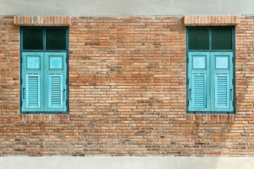 Retro classic image of two set of turquoise windows on old textured brick wall on peaceful summer day with copy space composition for advertising background.