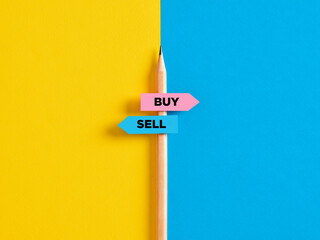 Buying or selling choice or decision. Pencil with direction indicator stickers showing the...