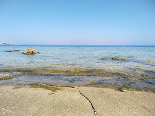 Beautiful view of the sea from a sandy beach with a rocky shore
